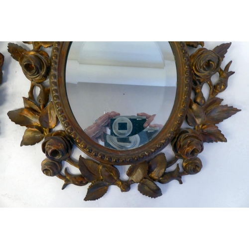 347 - A pair of late 19thC bevelled edge, oval mirrors, set in carved, giltwood, bead bordered, foliate de... 