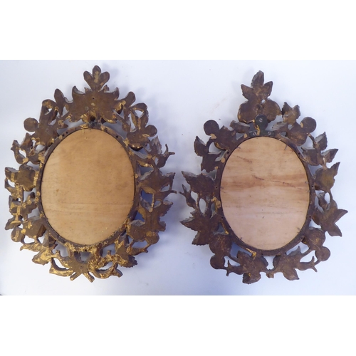 347 - A pair of late 19thC bevelled edge, oval mirrors, set in carved, giltwood, bead bordered, foliate de... 