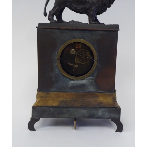 38 - A late 19th/early 20thC patinated and gilt bronze cased mantel clock, surmounted by a prowling lion,... 