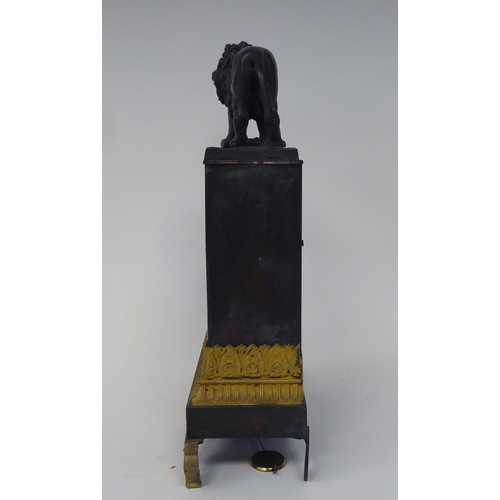 38 - A late 19th/early 20thC patinated and gilt bronze cased mantel clock, surmounted by a prowling lion,... 