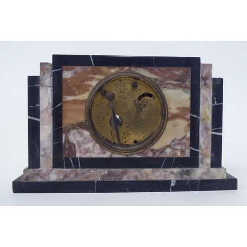 42 - An Art Deco black and mottled coloured marble cased manel timepiece; the 8 day movement faced by a s... 