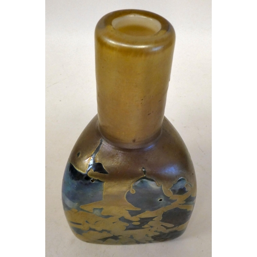 47 - In the manner of Loetz - a glass bottle vase of shouldered, triangular form, randomly decorated in g... 