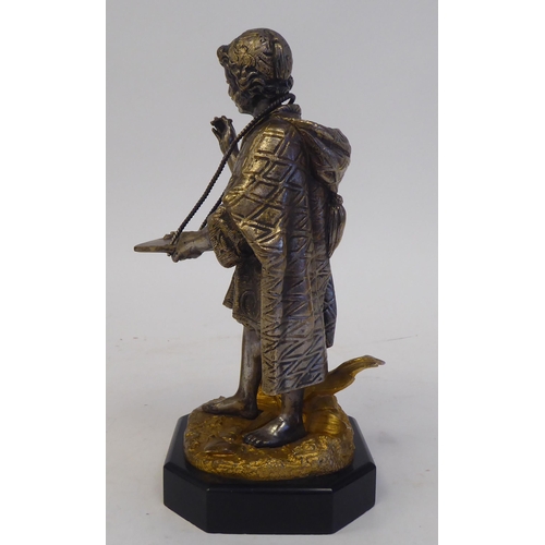 60 - A late 19thC Continental cast and bicoloured metal figure, a young itinerant salesman, on a black sl... 