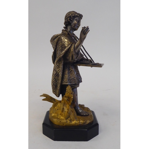 60 - A late 19thC Continental cast and bicoloured metal figure, a young itinerant salesman, on a black sl... 