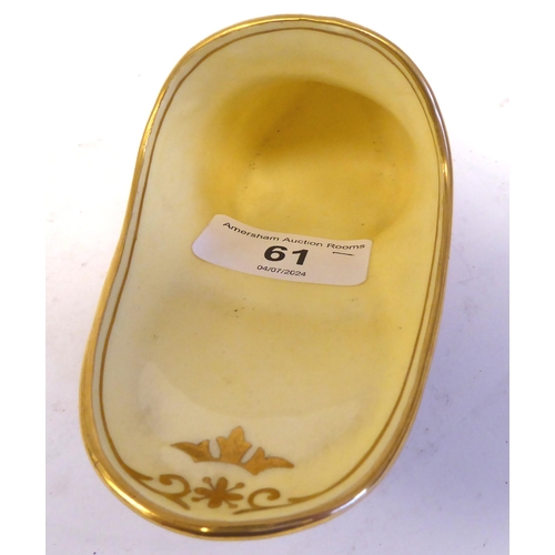 61 - A Coalport china model slipper, decorated in pale yellow and pink with applied sequins and highlight... 