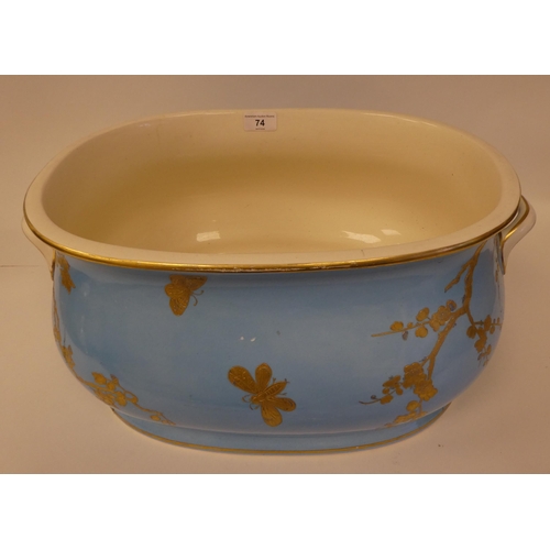 74 - A late 19thC china foot bath of oval, ogee form with opposing twin handles, decorated in off-white a... 