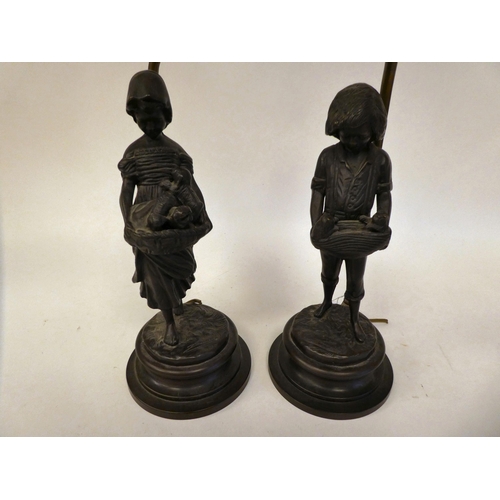 84 - A pair of cast and patinated bronze table lamps, depicting figures, a boy and a girl, carrying baske... 