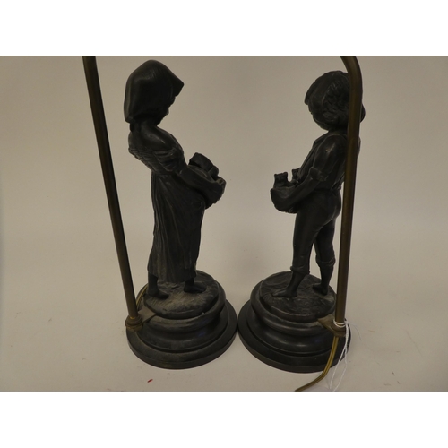 84 - A pair of cast and patinated bronze table lamps, depicting figures, a boy and a girl, carrying baske... 