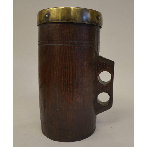 85 - A Victorian one-piece turned oak cylindrical mug with an integral handle and applied brass rim  impr... 