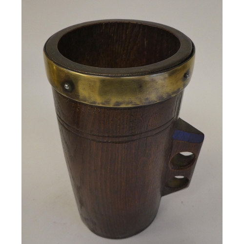 85 - A Victorian one-piece turned oak cylindrical mug with an integral handle and applied brass rim  impr... 