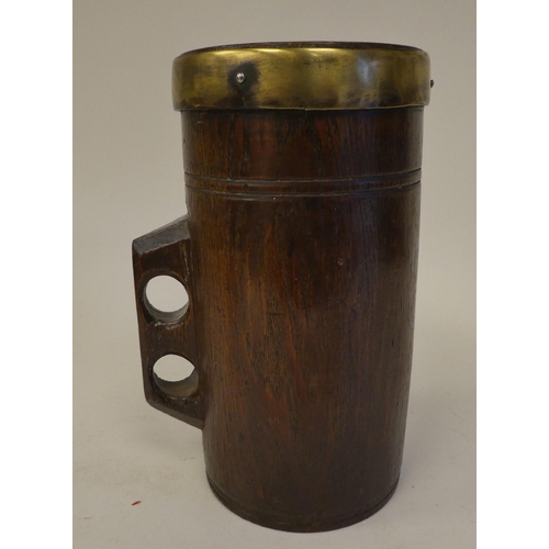 85 - A Victorian one-piece turned oak cylindrical mug with an integral handle and applied brass rim  impr... 