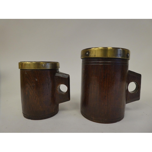 88 - Two, almost identical, Victorian one-piece cylindrical oak mugs with integral handles, applied brass... 