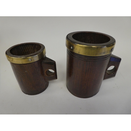 88 - Two, almost identical, Victorian one-piece cylindrical oak mugs with integral handles, applied brass... 