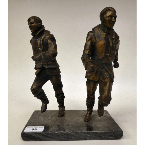 89 - A gilt bronze group, featuring two airmen, scrambling into action, on a grey marble plinth  11