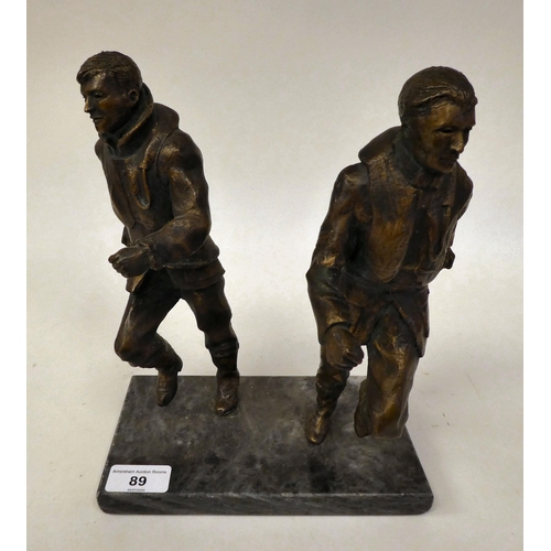 89 - A gilt bronze group, featuring two airmen, scrambling into action, on a grey marble plinth  11