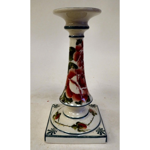 90 - A Wymess pottery candlestick with an integral, flared sconce and tapered stem, on a square base, tra... 