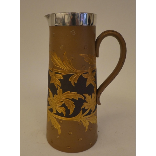 95 - A late Victorian Doulton Lambeth Siliconware water jug of tapered form, decorated with incised flora... 