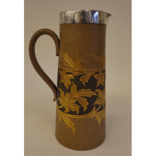 95 - A late Victorian Doulton Lambeth Siliconware water jug of tapered form, decorated with incised flora... 