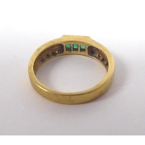 11 - A yellow metal emerald and diamond set ring  stamped 750