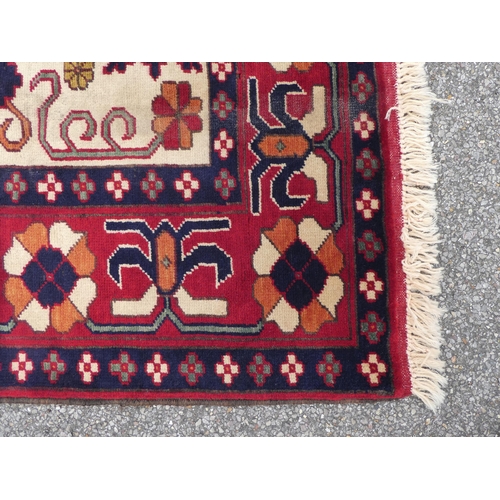 114 - An Afghan style rug, decorated with repeating stylised designs, on a multi-coloured ground  62