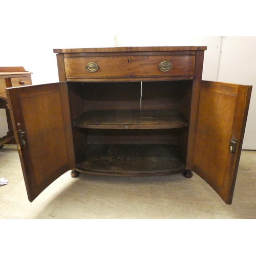 132 - A Regency mahogany bowfront sideboard with a frieze drawer, over two panelled doors, raised on turne... 