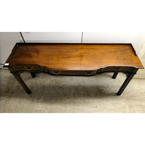 137 - A modern reproduction of a Georgian design, mahogany breakfront, three drawer hall table, raised on ... 