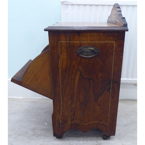 14 - An Edwardian rosewood purdonium with a fall front, on casters  25