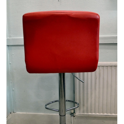 15 - A modern height adjustable bar stool, upholstered in red faux hide, on a chromium plated pedestal an... 