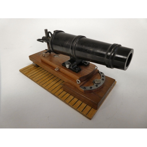 175 - A miniature model cannon with a bronze barrel, on a hardwood carriage  6.5