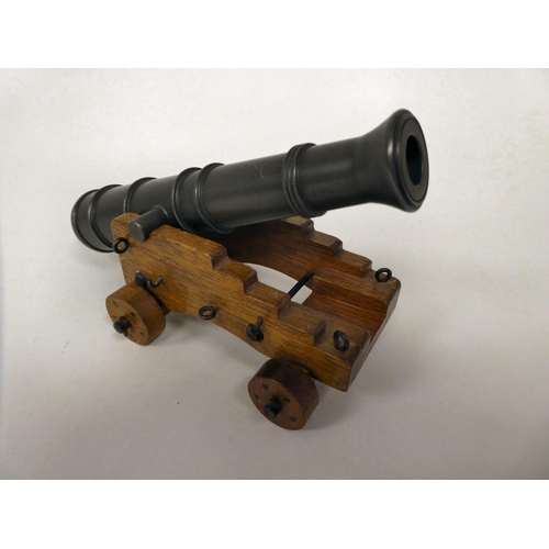 175 - A miniature model cannon with a bronze barrel, on a hardwood carriage  6.5