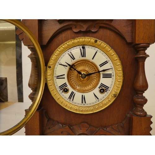 176 - A late 19thC American carved walnut cased mantel clock; the Ansonia movement faced by a two part Rom... 