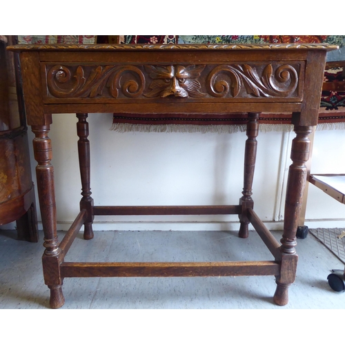 358 - A late Victorian oak hall table with a carved border and lion mask handle to the frieze drawer, rais... 