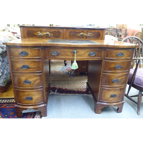 368 - A modern mahogany desk, the top set with a tooled green hide scriber, over two banks of four graduat... 