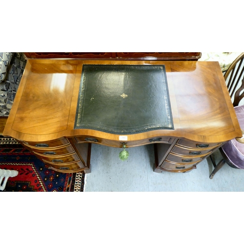 368 - A modern mahogany desk, the top set with a tooled green hide scriber, over two banks of four graduat... 