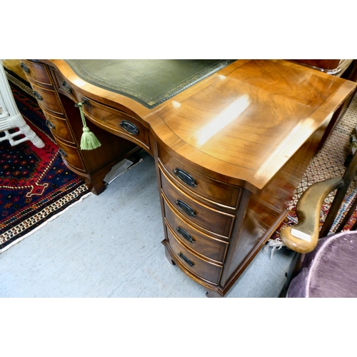 368 - A modern mahogany desk, the top set with a tooled green hide scriber, over two banks of four graduat... 