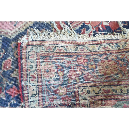 81 - A Persian rug, decorated with a central diamond shaped motif, bordered by stylised designs, on a mai... 