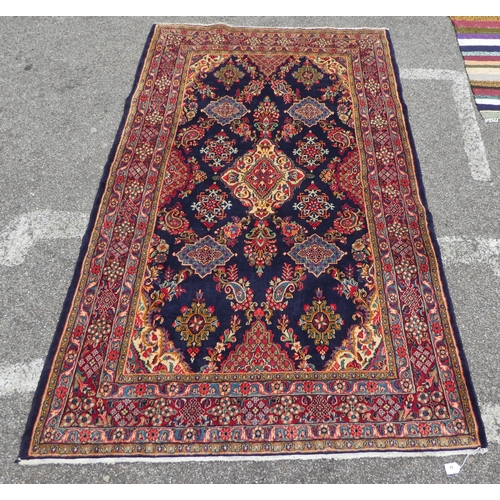 84 - An Iranian rug, decorated with repeating floral ornament, on a multi-coloured ground  53