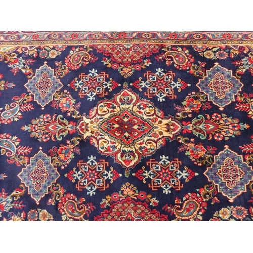 84 - An Iranian rug, decorated with repeating floral ornament, on a multi-coloured ground  53