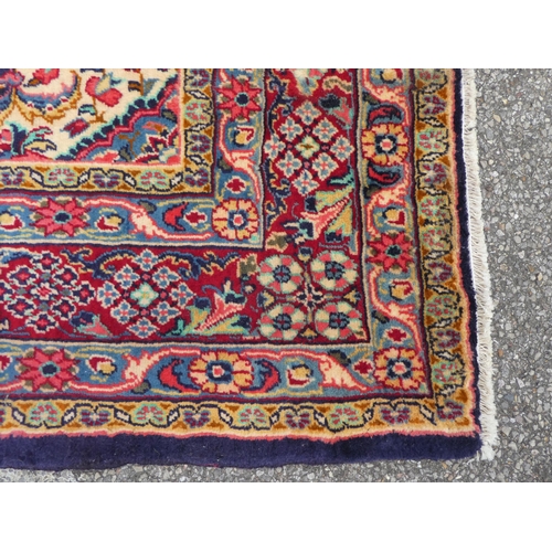 84 - An Iranian rug, decorated with repeating floral ornament, on a multi-coloured ground  53