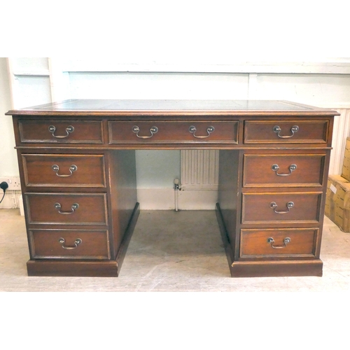 85 - A late 20thC Victorian style mahogany finished, nine drawer, twin pedestal desk with a tooled, blue ... 