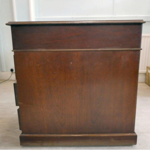 85 - A late 20thC Victorian style mahogany finished, nine drawer, twin pedestal desk with a tooled, blue ... 