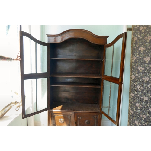 91 - An early 20thC oak round arched, cabinet bookcase, the pair of three-quarter height, glazed panelled... 