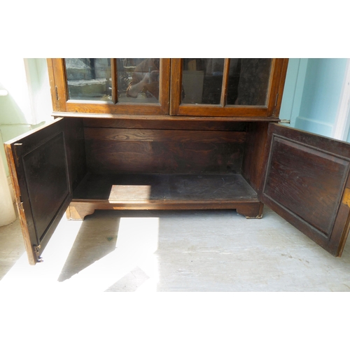 91 - An early 20thC oak round arched, cabinet bookcase, the pair of three-quarter height, glazed panelled... 