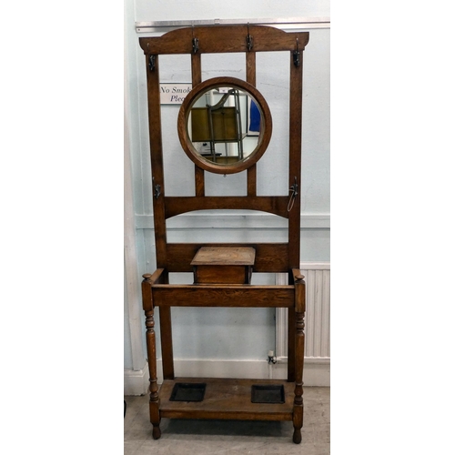 98 - An early 20thC light oak framed hall stand, comprising iron coat hooks, a vanity mirror, glove box a... 