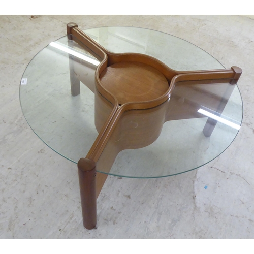 109 - A 1960s laminated teak coffee table of star design with three inset, clear glass panels, around a ce... 