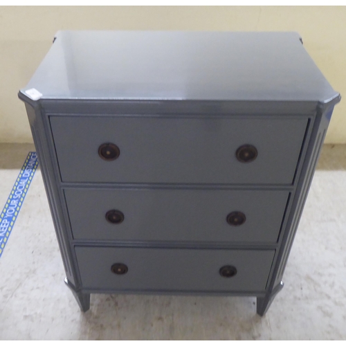 31 - A modern dark grey painted, three drawer dressing chest, raised on tapered legs  32