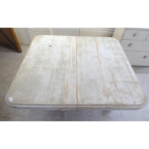 38 - An early 20thC shabby chic painted pine, two-part coffee table, the top with rounded corners, on fou... 