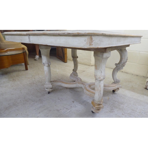 38 - An early 20thC shabby chic painted pine, two-part coffee table, the top with rounded corners, on fou... 