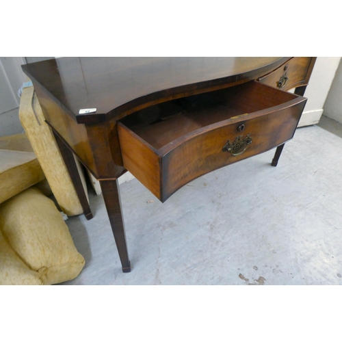 44 - A 20thC Georgian reproduction of a mahogany serpentine front, two drawer serving table, raised on sq... 