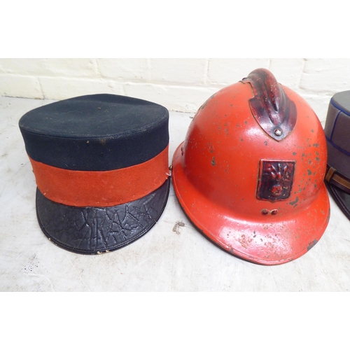 48 - Two World War II firefighters helmets; and three contemporary peaked caps(Please Note: this lot is s... 